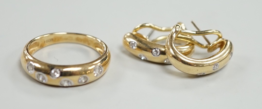 A modern 14k and gypsy set six stone diamond band, size N and a pair of matching earrings, gross weight 8.1 grams.